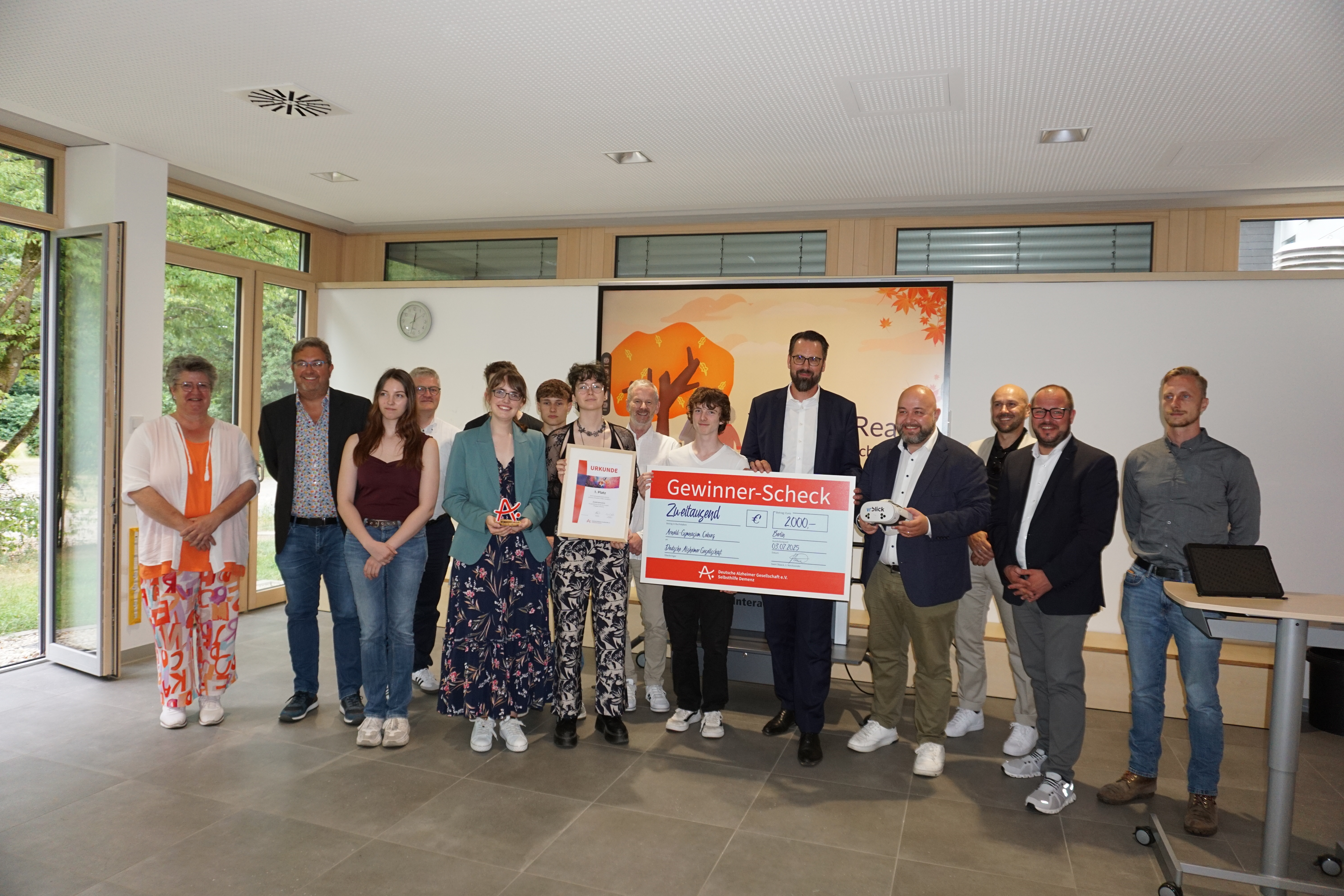 Die Gewinnerinnen und Gewinner in einer Gruppe bei der Scheckübergabe